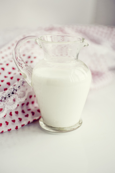 Glass jar of milk on a white surface - Foto, Bild