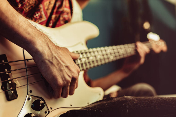 Close up of male hand playing electric guitar in the dark - Φωτογραφία, εικόνα