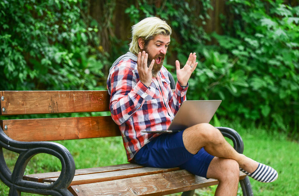 mature student working on computer. go shopping on cyber monday. man sit on bench with laptop. online distant education. hipster inspired to work in park. agile business. Concentrated on studying - Foto, immagini