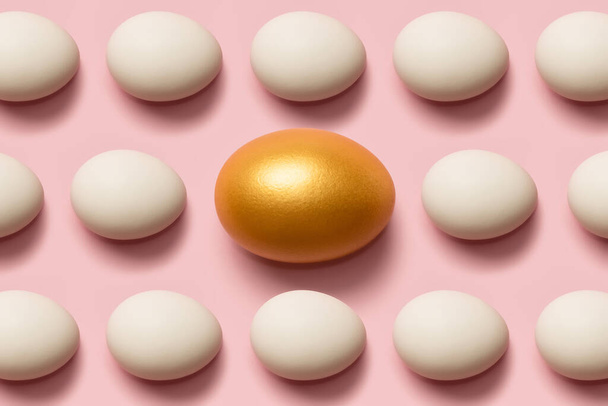 Begrip individualiteit, exclusiviteit, betere keuze. Een gouden ei tussen witte eieren. Bovenaanzicht. - Foto, afbeelding