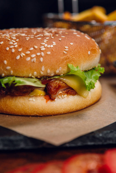 Burger s hranolkama a kečupem na stole v restauraci. Rychlé občerstvení, nezdravé jídlo - Fotografie, Obrázek