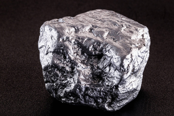 zilver nugget afkomstig uit Liberia geïsoleerd op zwarte achtergrond. Zeldzame steen voor industriële ertswinning - Foto, afbeelding
