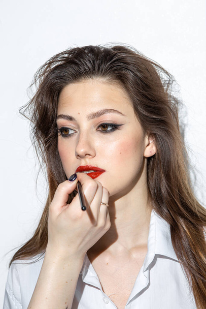 Beauty portrait of a girl with makeup with red lips - Фото, изображение