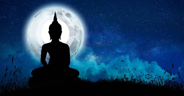 Будда медитировал среди многих звезд и большой луны
. - Фото, изображение