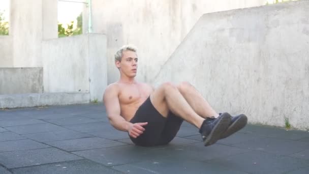 Man doing exercises for abdominals outdoors. Alone workout on fitness area - Footage, Video
