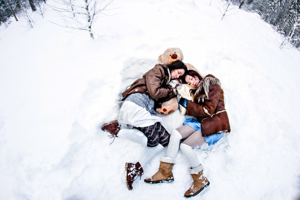 Mujeres de moda acostadas sobre nieve blanca fondo de invierno ojo de pez
 - Foto, imagen