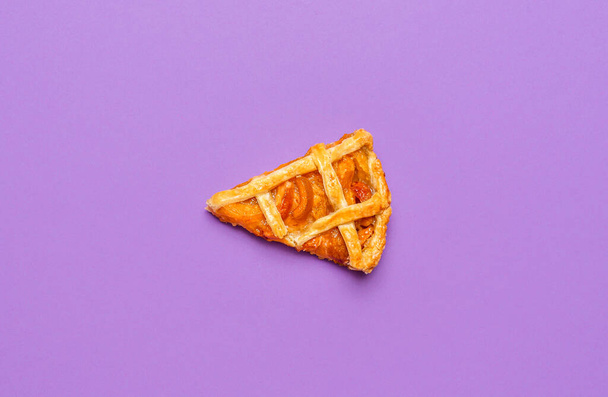 One slice of apricot pie with a lattice crust, isolated on purple seamless background. Top view of homemade apricots pie. Thanksgiving dessert slice. - Photo, Image