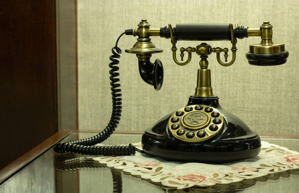 Антикварный телефон на столе в лобби отеля
 - Фото, изображение