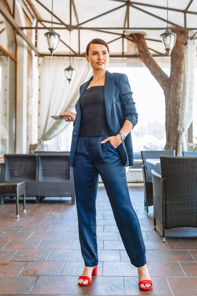 Business girl in a blue suit, resting in a restaurant - Фото, зображення