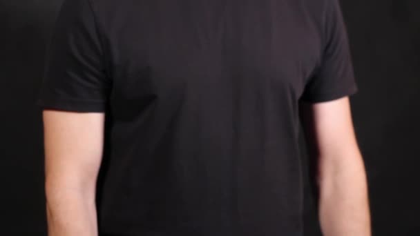 Mãos masculinas caucasianas em uma camiseta de manga curta, puxando dois punhos para cima
 - Filmagem, Vídeo