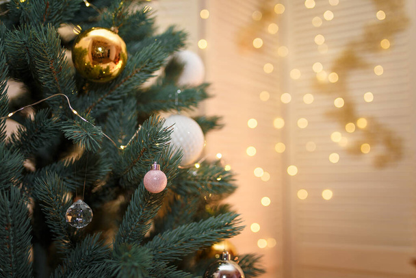 Καλά Χριστούγεννα και ευτυχισμένο το νέο έτος έννοια, Closeup λευκό και χρυσό στολίδια κρέμονται από ένα διακοσμημένο δέντρο με bokeh, Χριστούγεννα διακοπές και γιρλάντα φώτα φόντο. αντίγραφο χώρου. - Φωτογραφία, εικόνα