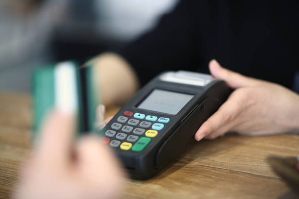Cliente que usa tarjeta de crédito para pagar en un café
 - Foto, Imagen