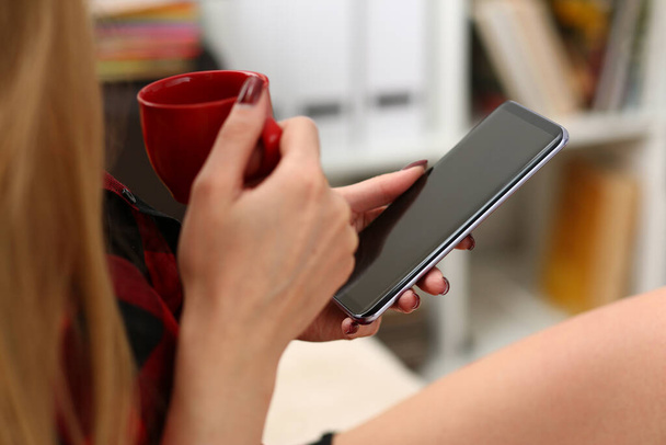 Mujer bebiendo café y mirando en pantalla gadget
 - Foto, Imagen