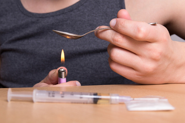 наркоман, Отопление наркотиков в ложке над пламенем - Фото, изображение