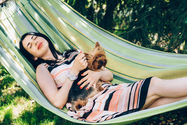 Menina dormir em rede na natureza com um cão em seus braços
  - Foto, Imagem