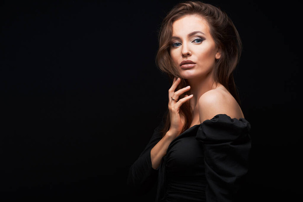 Fashion photo of a sexy caucasian woman with brown hair and bright makeup posing at studio - Photo, Image