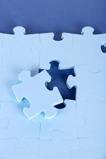Last piece of jigsaw puzzle, close-up, on blue background - Zdjęcie, obraz