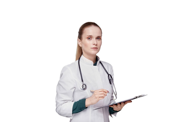 A doctor holds a clipboard and looks at the camera. Isolated background. - Fotografie, Obrázek