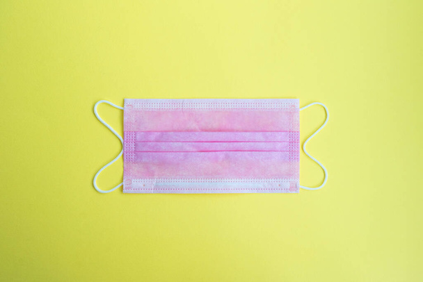 One surgical medical mask on a yellow background - Photo, Image