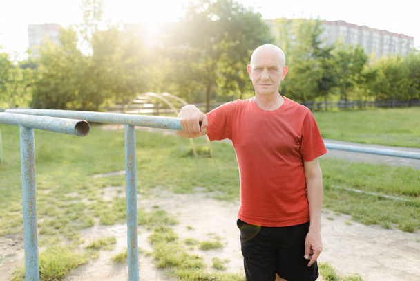 Retrato de homem do esporte de meia idade fazendo exercício no parque
. - Foto, Imagem