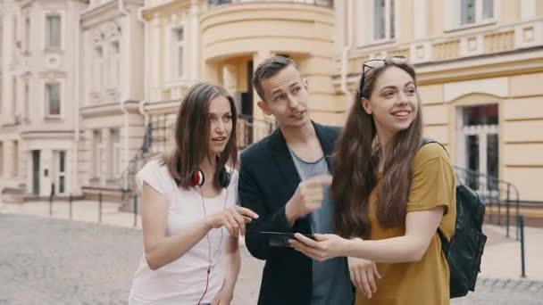 Fiatal baráti társaság turisták keresi a térképet az okostelefon próbál megtalálni a helyes utat - Felvétel, videó
