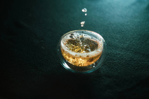 greentea is poured Into a glass mug, splashes and bubbles - Valokuva, kuva