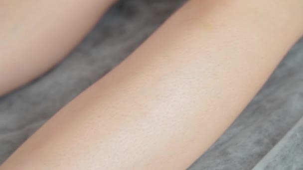 A kozmetikus felkészíti egy fiatal nő lábát a nyírásra.. - Felvétel, videó