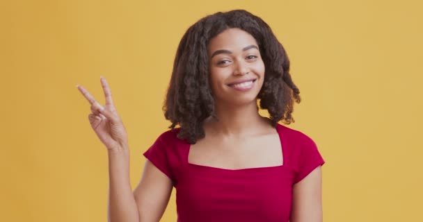 Boldog afro-amerikai lány felemeli a kezét és gesztikulál a béke - Felvétel, videó