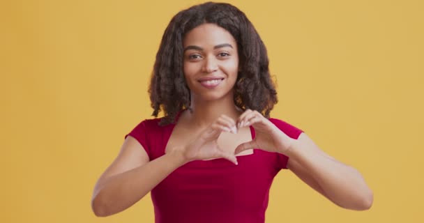 Romantic african american girl making heart sign with fingers - Video