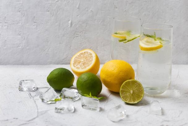 Cold lemonade with ice. Tasty lemonade with lemon, lime and mint. Summer refreshing drink - Фото, изображение