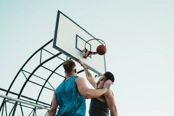 Young basketball players playing one-on-one on outdoor court. Sport and basketball concept. - Photo, image
