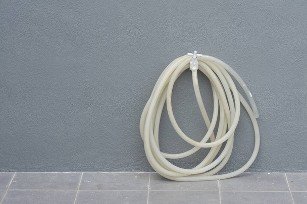 roll of rubber garden hose hang on the pvc faucet. - Fotografie, Obrázek