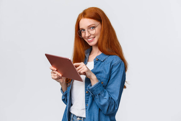Wait-up portrait coquettish and flirty cute redhead woman flirting with team member during meeting, holding digital tablet, looking seductive camera with alluring smile, white background - Foto, Bild