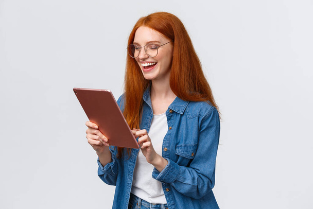 Derékig érő portré boldog vidám vörös hajú barátnő beszél partner segítségével internetes video-call szolgáltatás, nevetve boldogan, szórakozás, mosolygós modul kamera, álló fehér háttér - Fotó, kép