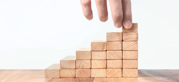 Hand holds wooden blocks on a white background - Photo, Image