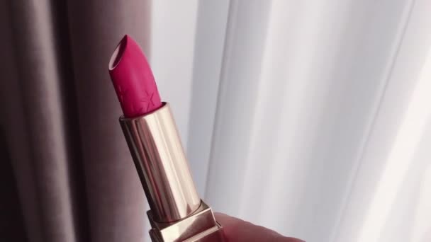 Różowa szminka w złotej tubie jako luksusowy produkt kosmetyczny, makijaż i uroda - Materiał filmowy, wideo