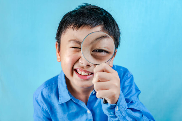 Little boy holding Magnifying glass - Фото, зображення