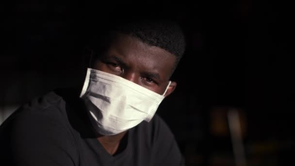 giovane uomo africano indossando maschera chirurgica - Filmati, video