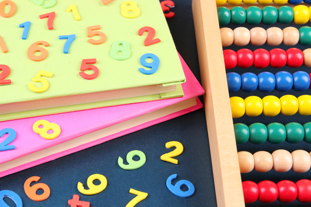 Colorful numbers, abacus and books on school desk background - Foto, imagen