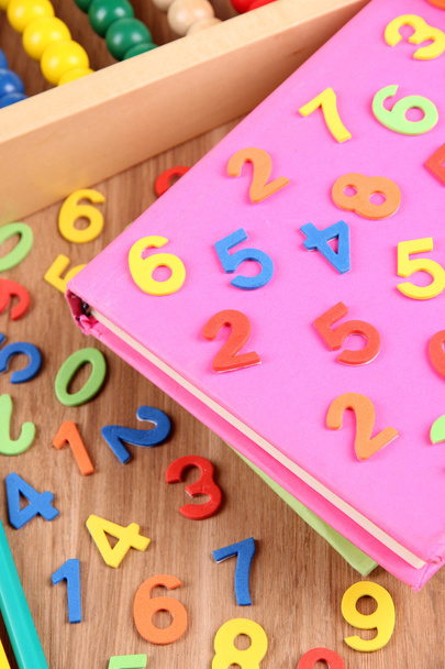 Colorful numbers, abacus, books and markers on wooden background - Foto, imagen