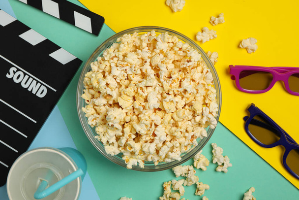 Composition with bowl of popcorn on multicolor background - Foto, afbeelding