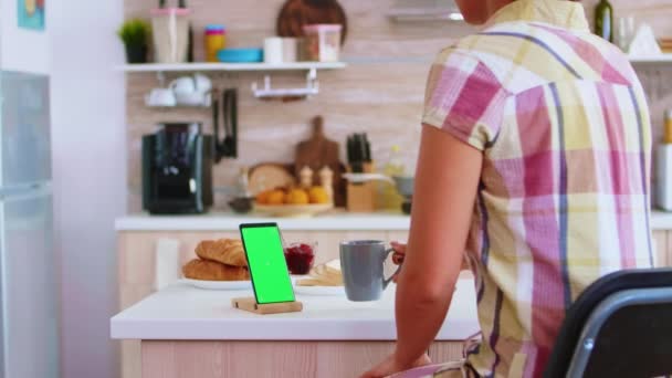 Ama de casa mirando el teléfono móvil con pantalla verde
 - Metraje, vídeo