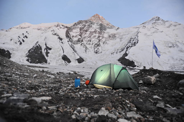 Khan Tengri / Kazajstán - 07.27.2011: Carpas para la noche. Campamento de alpinistas al pie de la montaña Khan Tengri
. - Foto, imagen