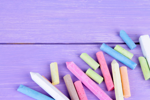 Chalks in variety of colors, on wooden background - Fotoğraf, Görsel