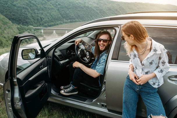 Two Young and Trendy Traveling Hipsters Having Fun Enjoying Road Trip Travel Concept - 写真・画像
