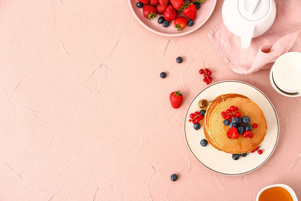 Сладкие блинчики с ягодами на цветном фоне
 - Фото, изображение