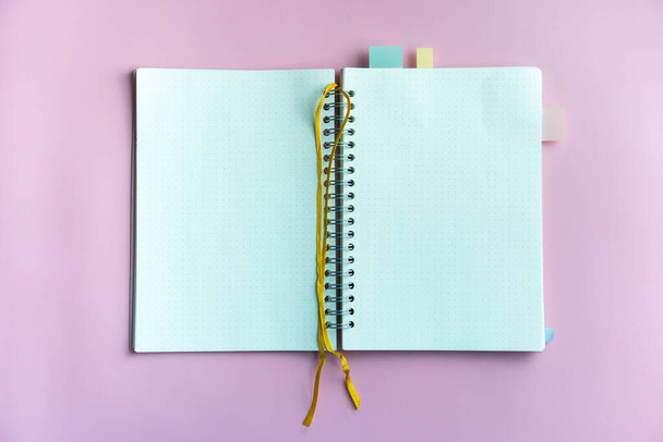 Horní pohled na prázdný prostor bílý notebook a pero s tropickým listem jako rámeček pozadí. - Fotografie, Obrázek