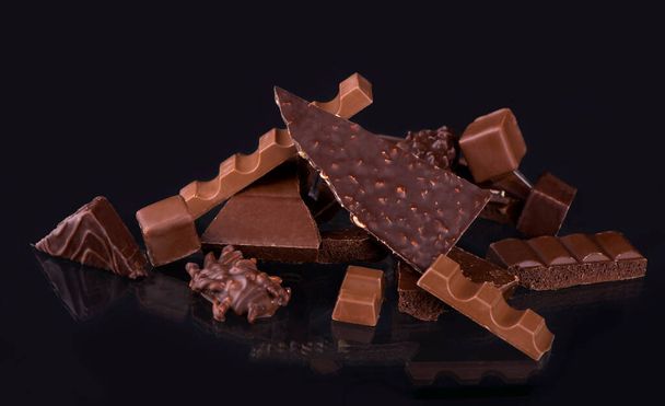 Broken chocolate pieces and cocoa powder on wooden background - Foto, immagini