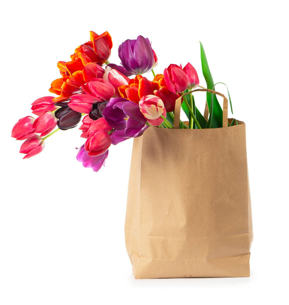 fleurs colorées dans un sac artisanal isolé sur blanc - Photo, image