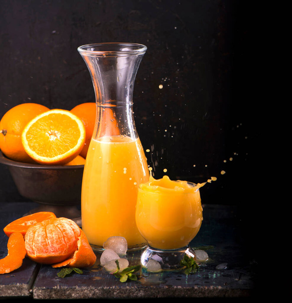 glass of fresh orange juice with fresh fruits on wooden table - Foto, afbeelding